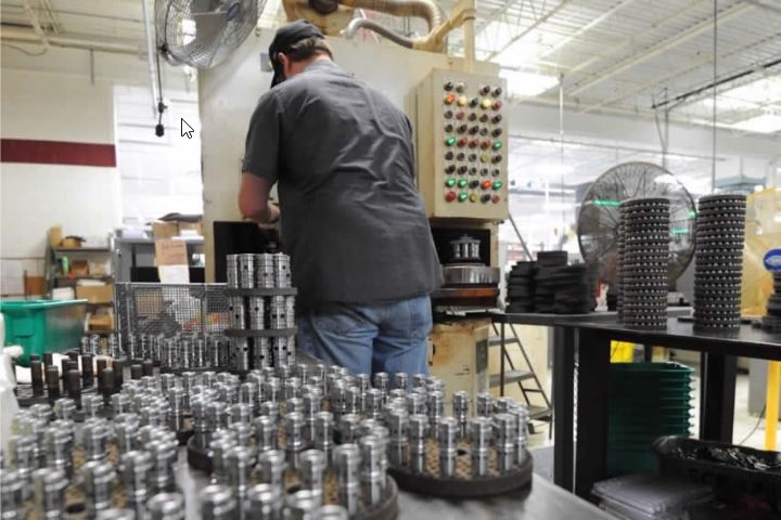 Operator inspecting precision parts – Swiss Automation facility