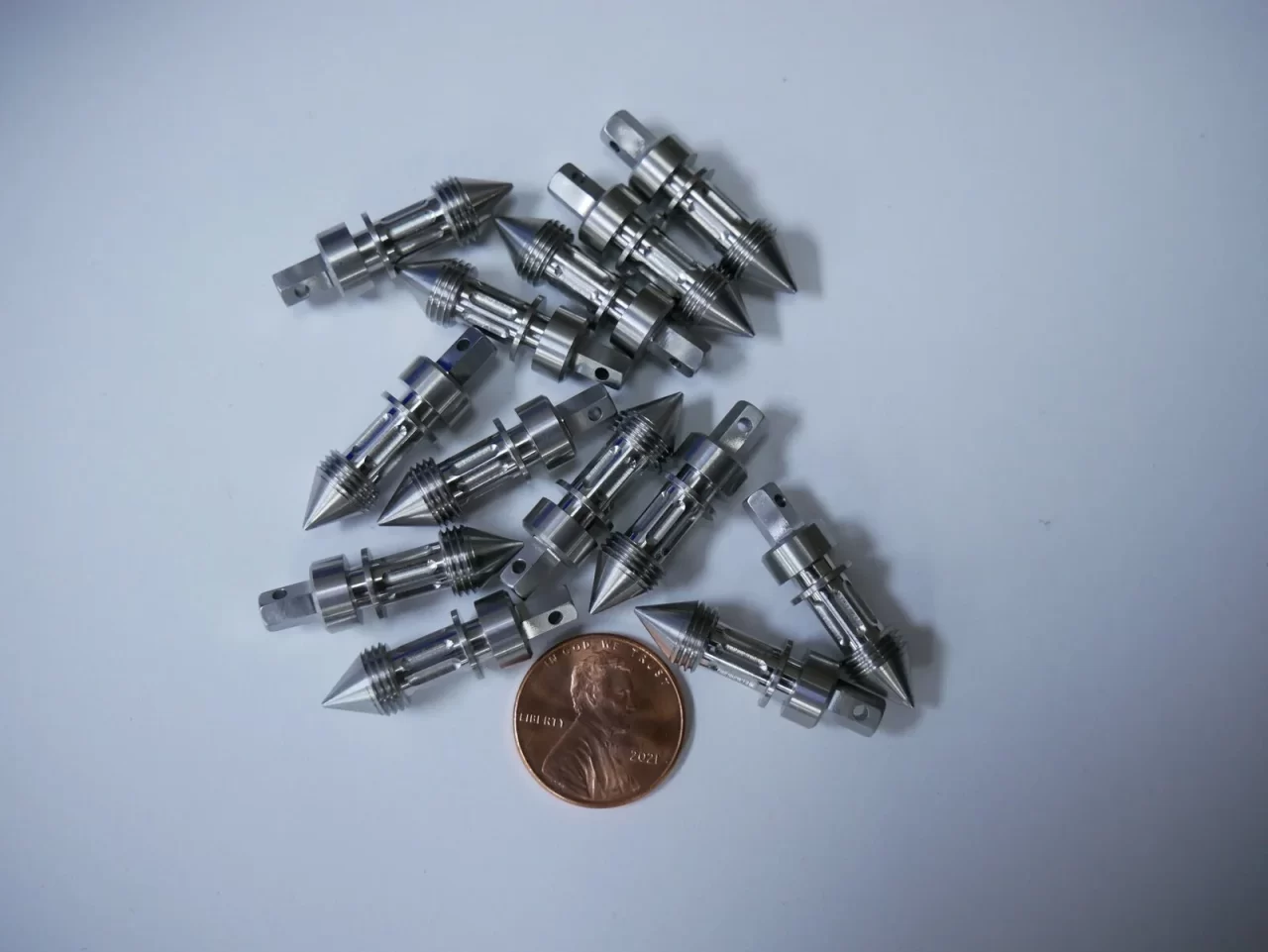 Small machined pins with penny for scale – Chesapeake CNC